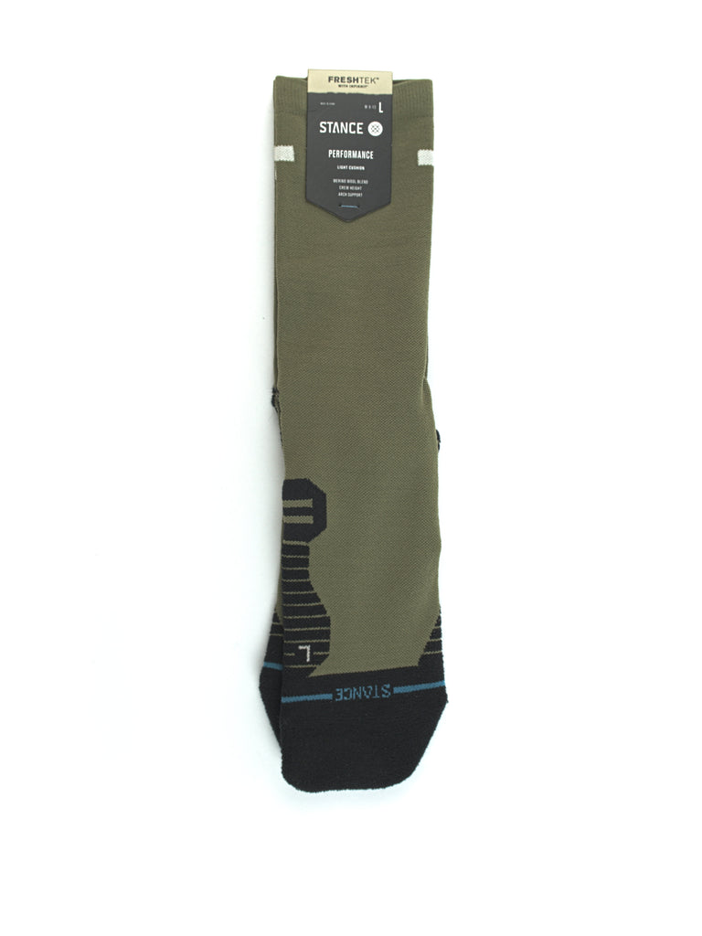 Olive green sock with black accents and a product label attached.