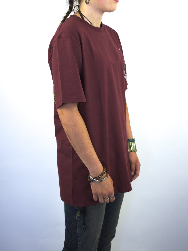 Burgundy oversized t-shirt worn by a person.