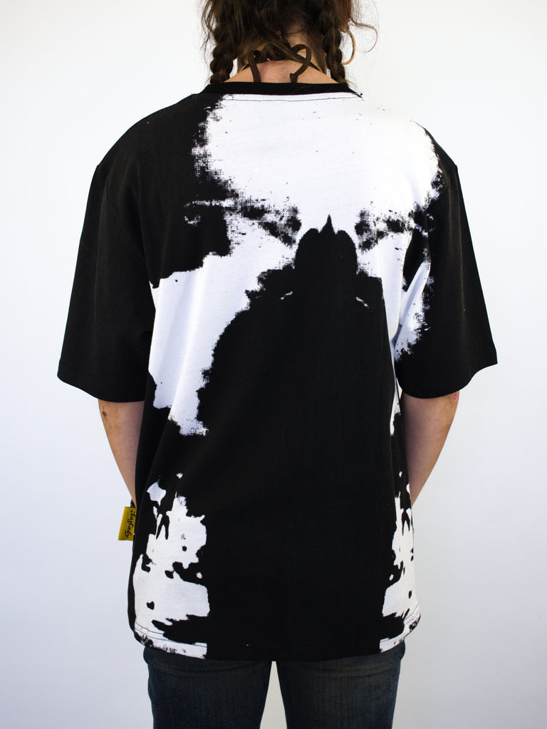 T-shirt with a black and white abstract pattern on the back.