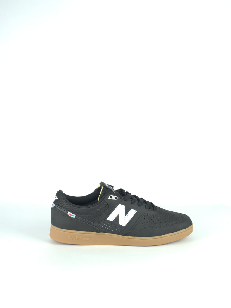 Black New Balance sneaker with a gum sole and white ’N’ logo.