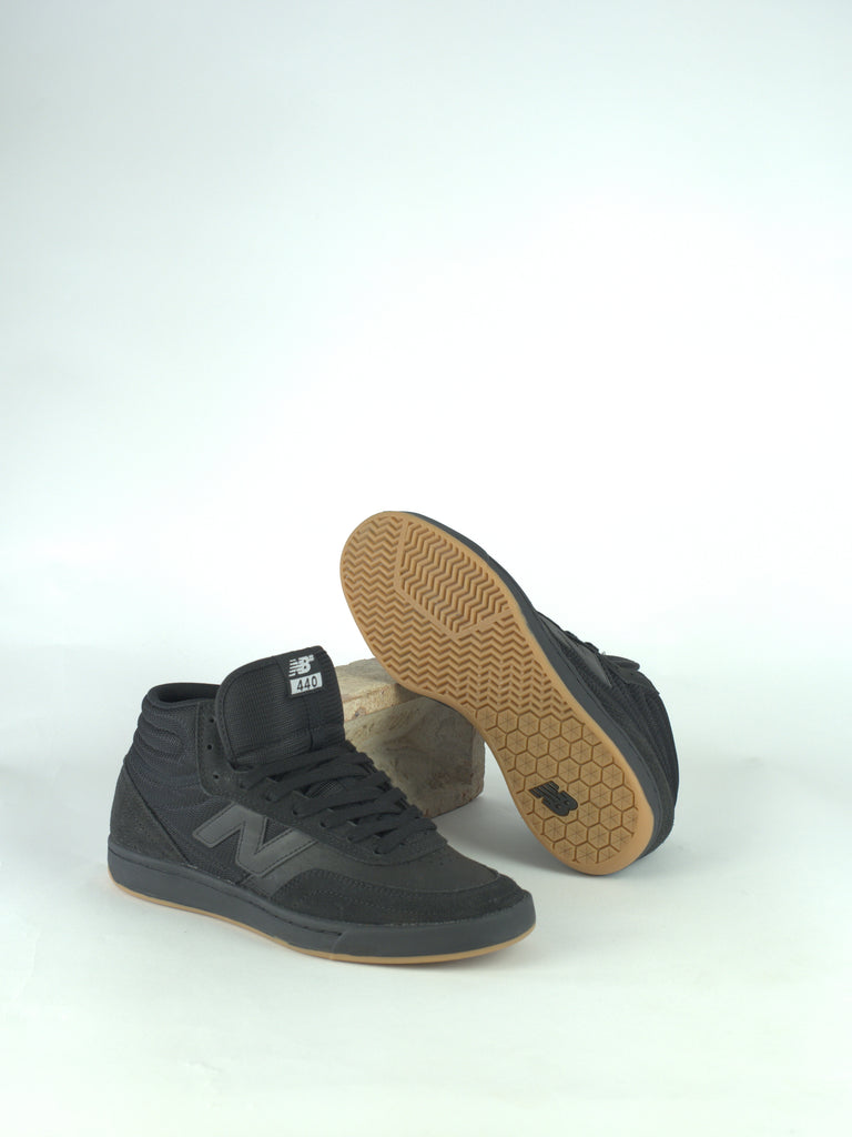 Pair of black high-top sneakers with gum soles.