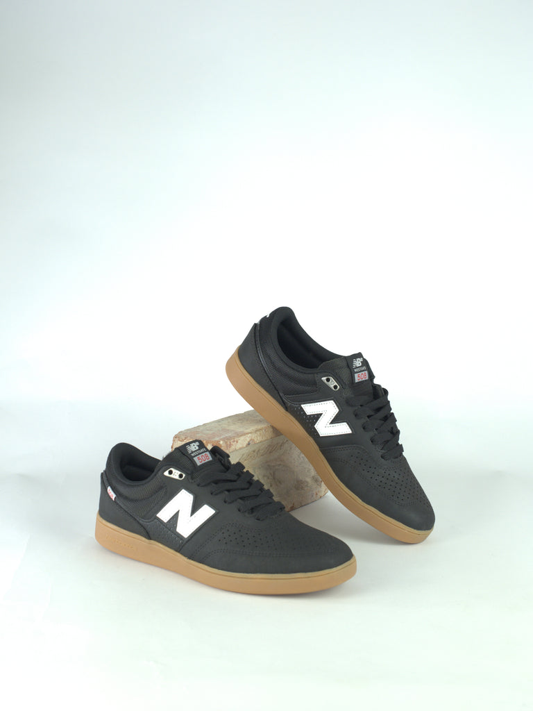 Pair of black New Balance sneakers with white ’N’ logos and gum soles.