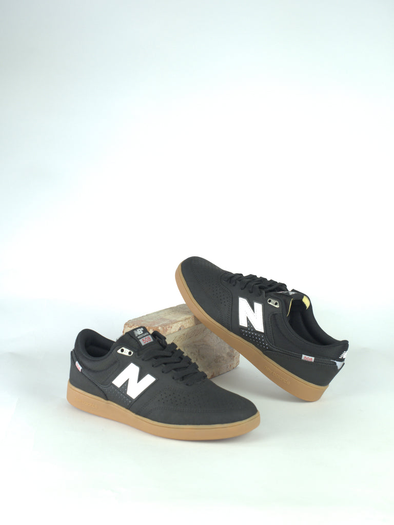 Pair of black New Balance sneakers with white ’N’ logos and gum soles.