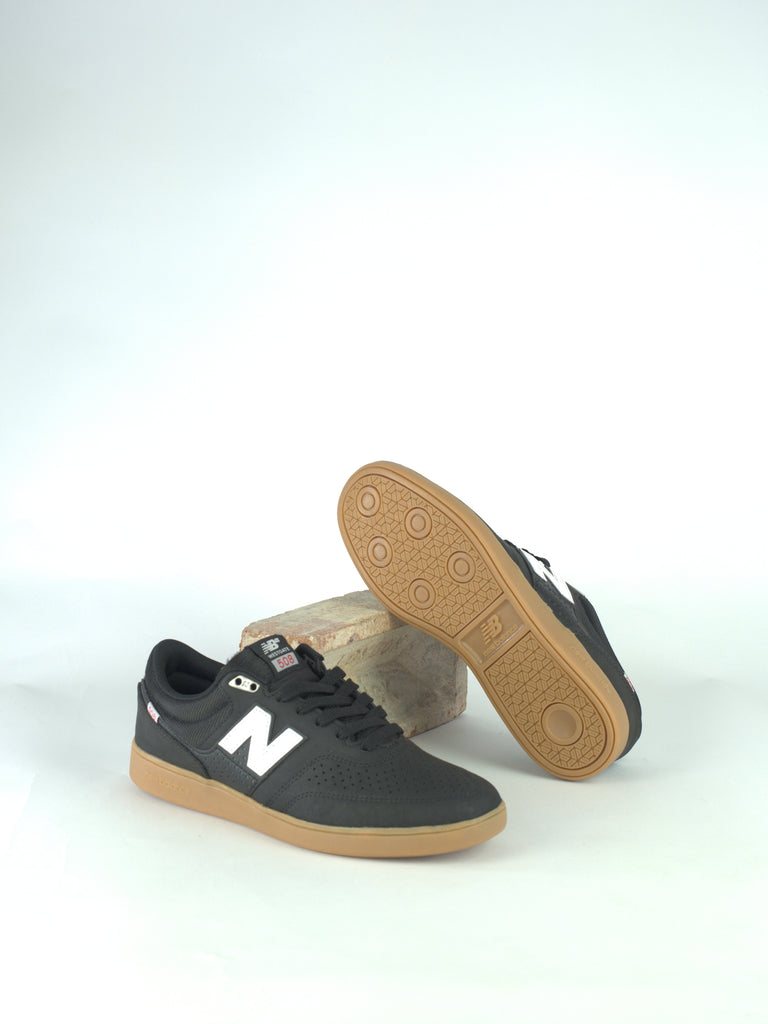 Pair of black New Balance sneakers with white logo and gum soles.