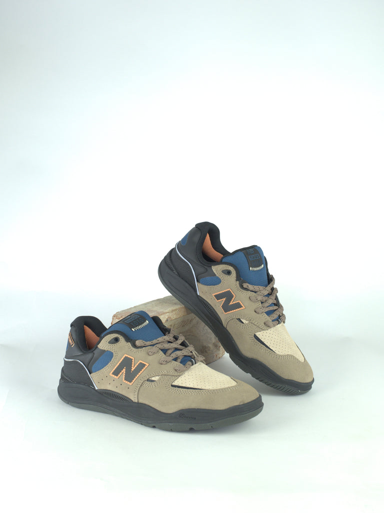 Pair of New Balance sneakers in beige, blue, and orange colors.