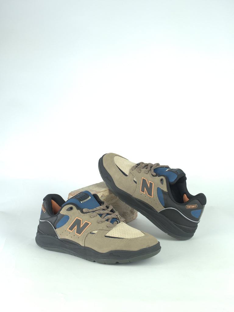 Pair of New Balance sneakers in beige, blue, and gray colors.