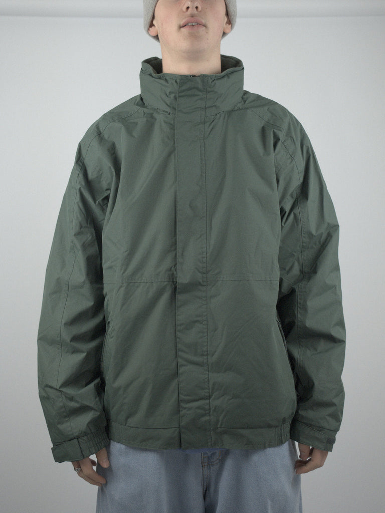 Green waterproof fleece lined jacket with high collar and zipper closure in Forest Green