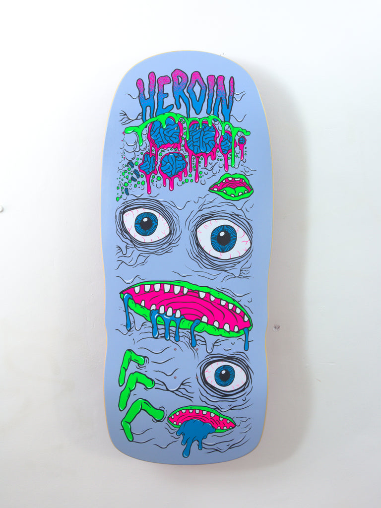 Colorful, graffiti-style skateboard deck featuring a surreal face design with multiple eyes and mouths.