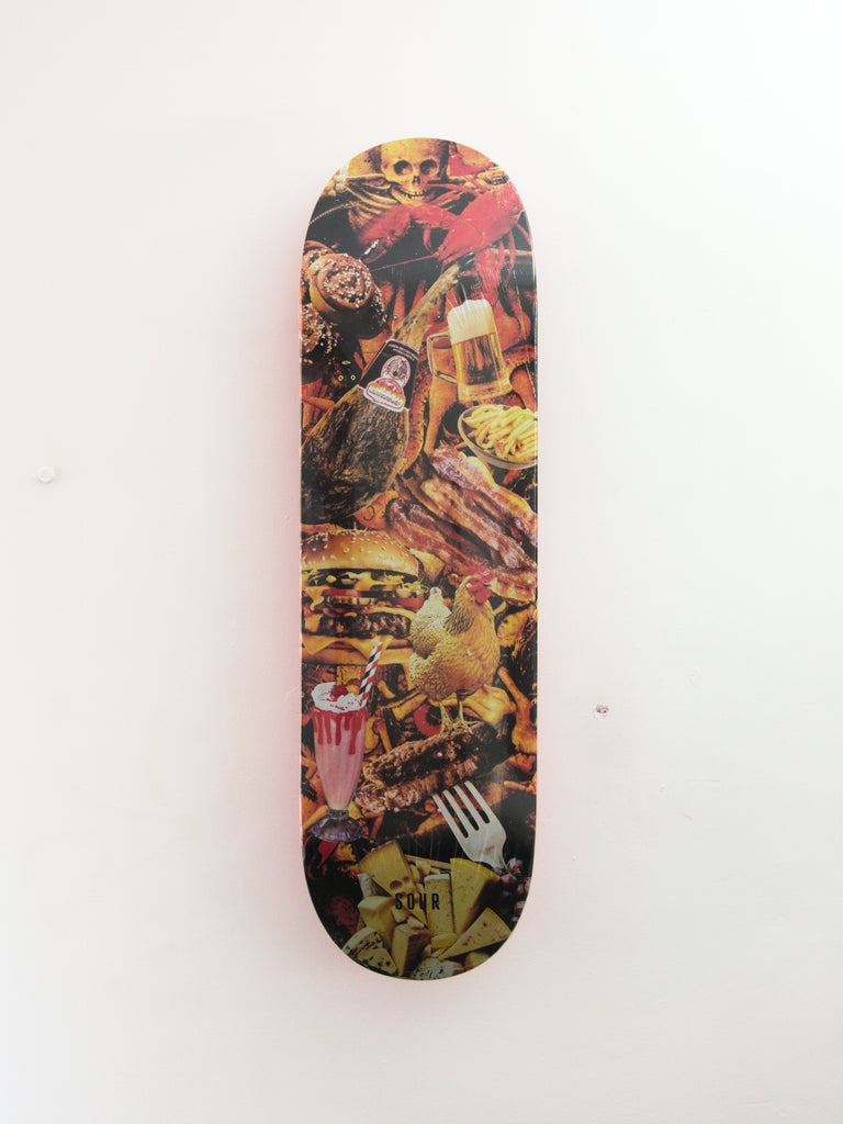 Skateboard deck decorated with a collage of punk rock and graffiti-style artwork.