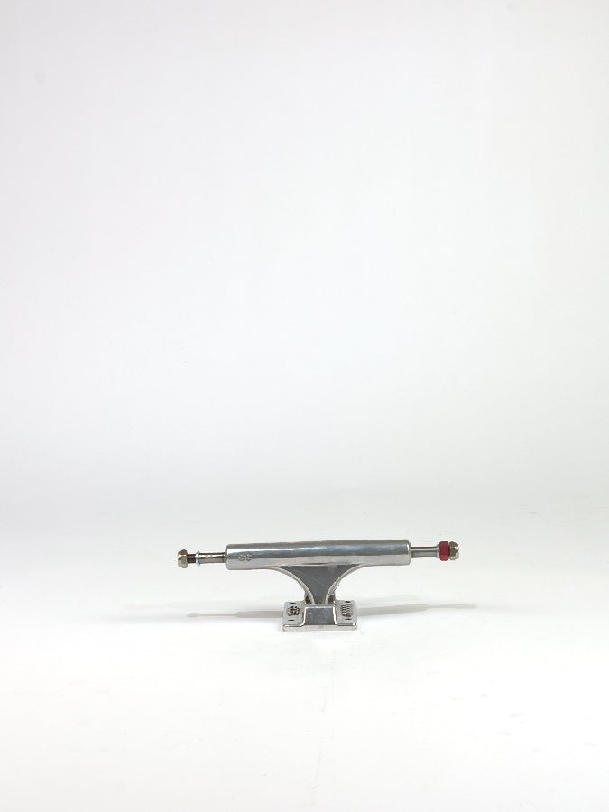 Skateboard truck with a silver metallic finish and red bolt.