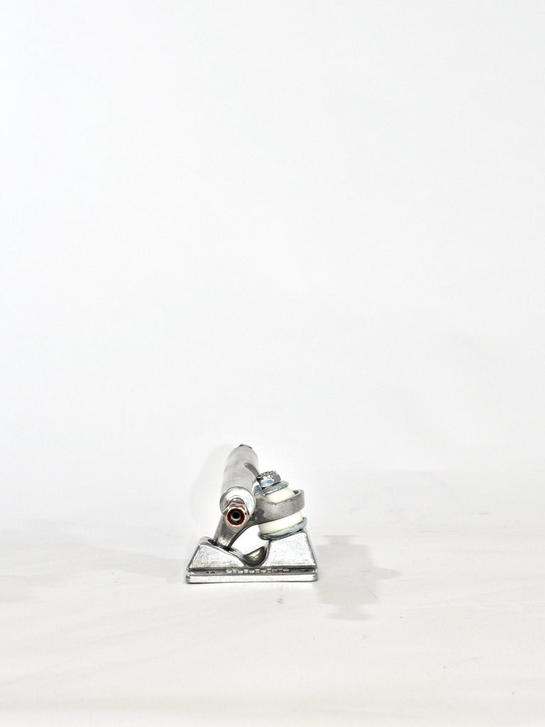 Skateboard truck made of metal with visible mounting holes and pivot mechanism.