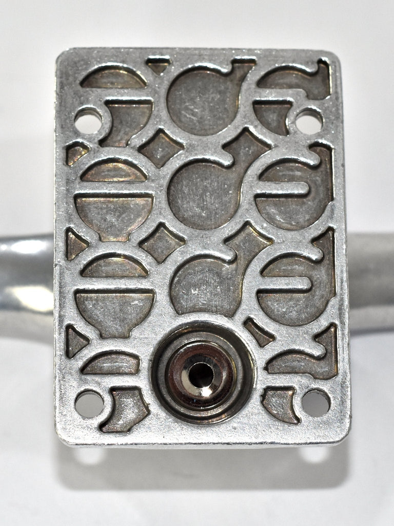 Decorative metal plate with intricate cutout patterns and a central circular opening.