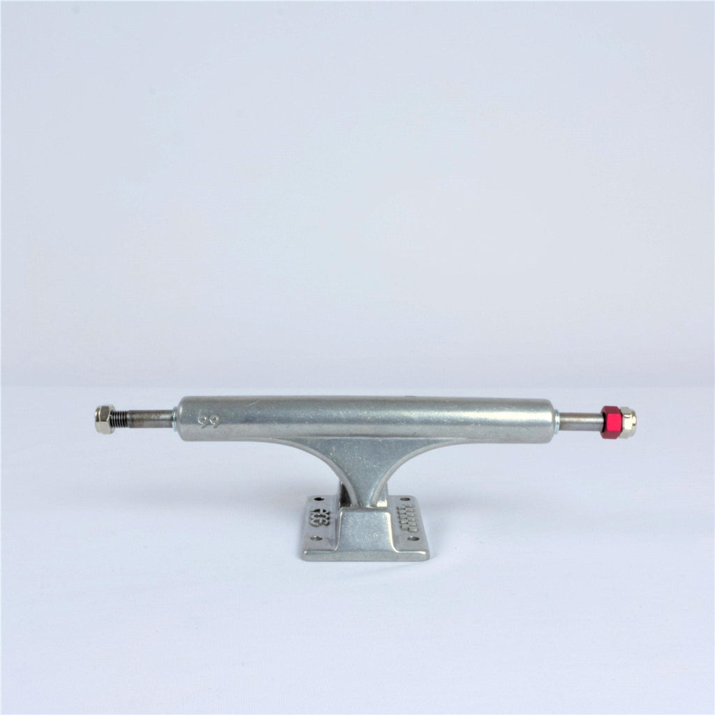 Skateboard truck made of silver metal with a red bushing.