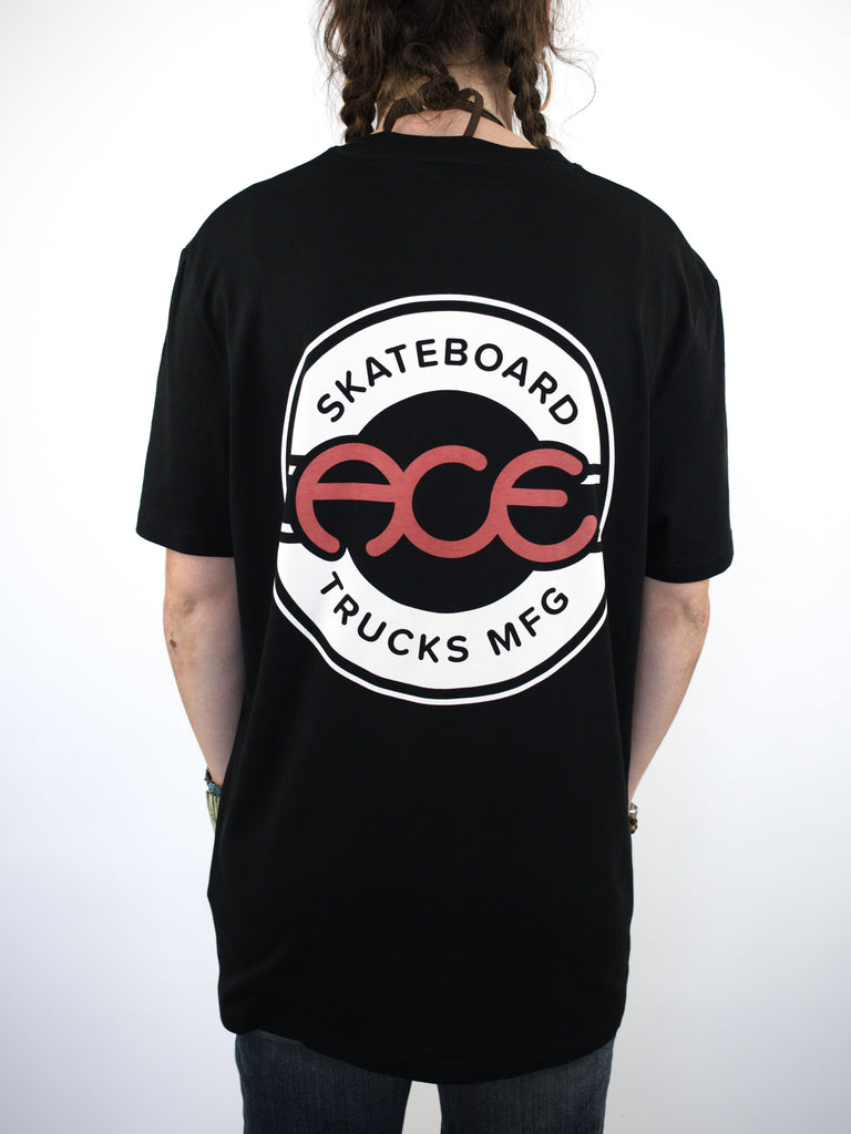 Black t-shirt with a circular ’Skateboard Trucks MFG’ logo on the back.