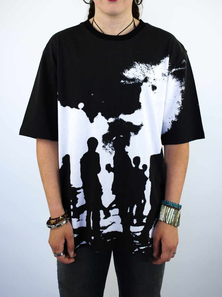 Black t-shirt with a white silhouette design depicting a group of people against a moonlit sky.