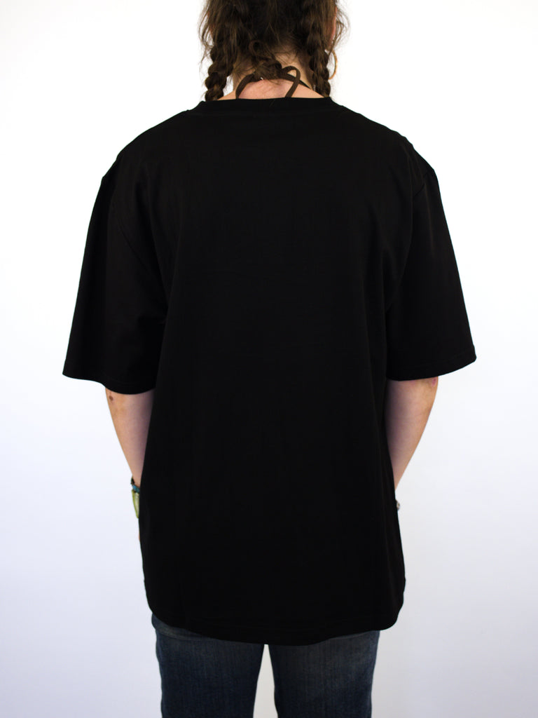 Black oversized Warp Tee Shirt from Bag Lady Supplies, worn by a person with braided hair