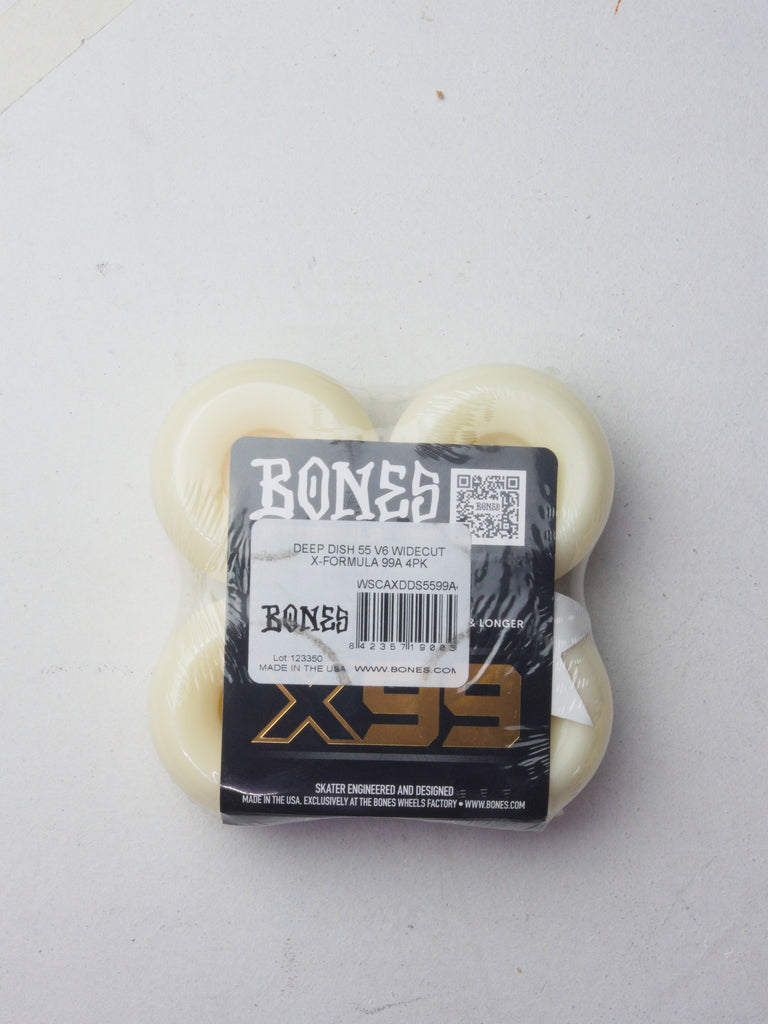 Set of four white Bones skateboard wheels with product packaging.