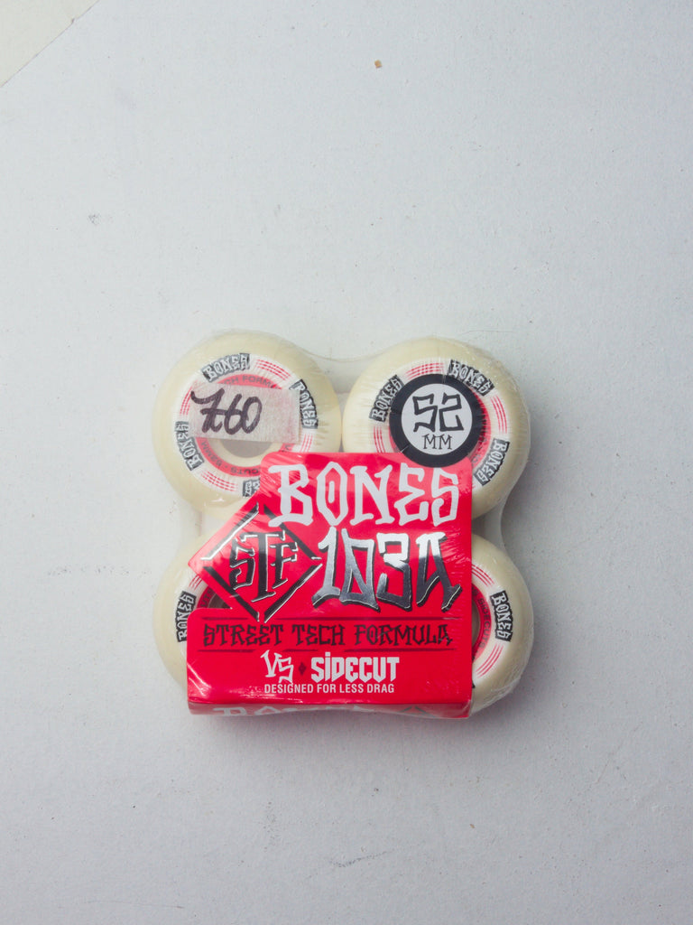 Set of four white Bones skateboard wheels with red packaging and black text.