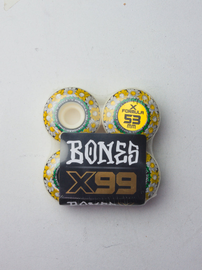 Set of four white and yellow speckled Bones skateboard wheels with X99 branding.