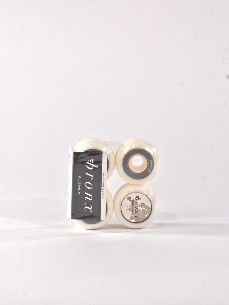 Set of four white skateboard wheels with branding visible.