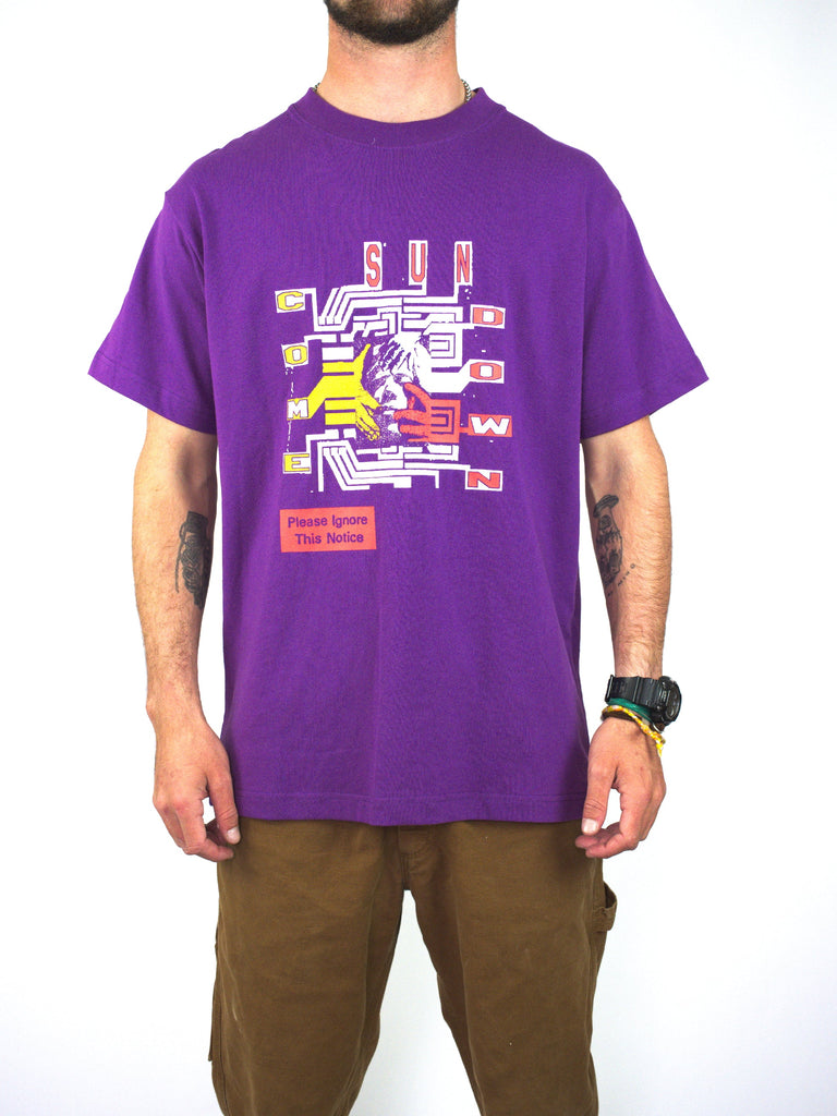 Bright purple t-shirt with colorful geometric graphic design on the front.