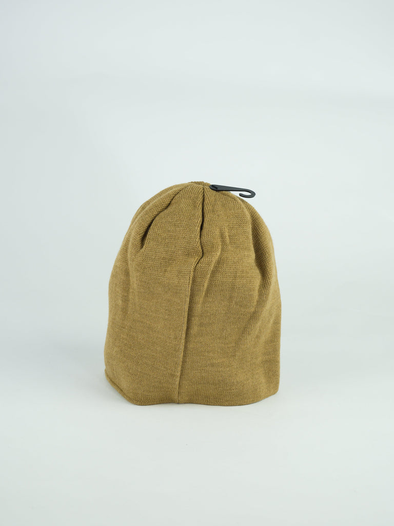 Tan canvas beanie with vertical seams.