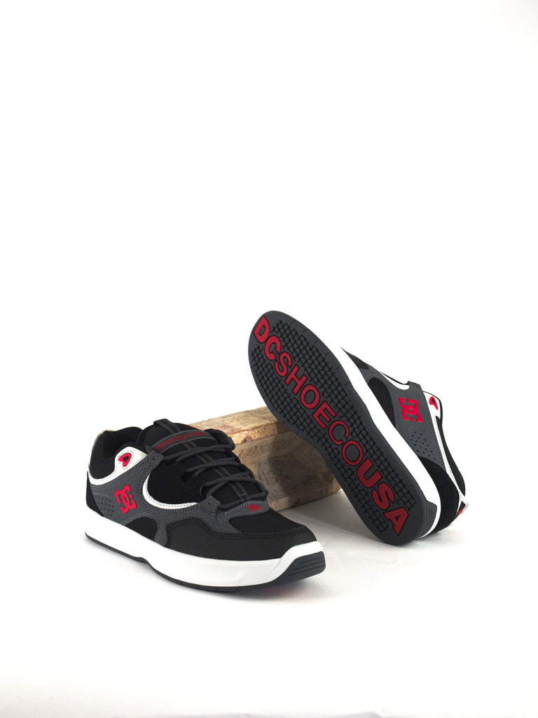 Black and grey sneakers with red accents and white soles.