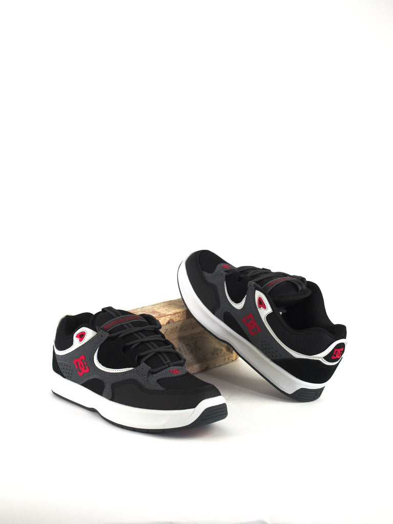 Pair of black Nike sneakers with white swoosh logos and red accents.