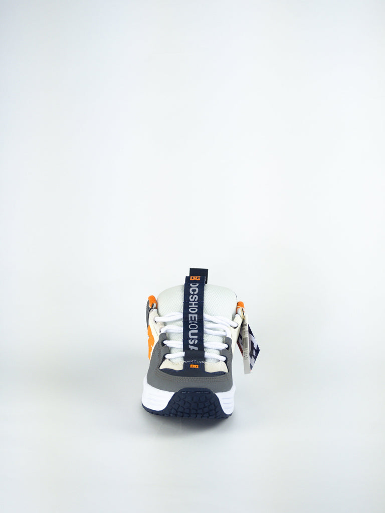 Athletic sneaker with orange and black accents on white base.