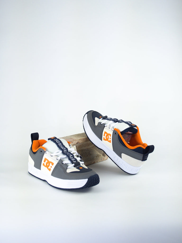 DC brand skateboarding shoes in white, gray, and orange colors.