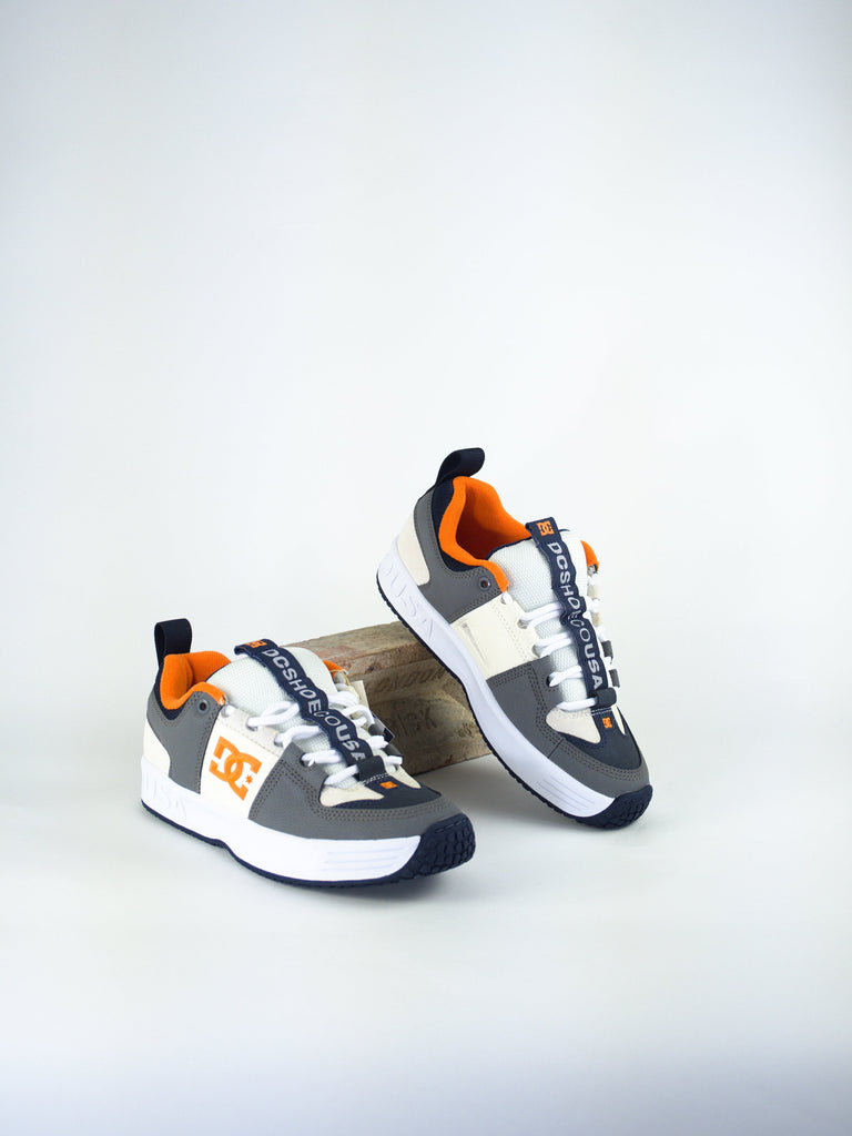 DC brand athletic sneakers in white, gray, and orange colors.