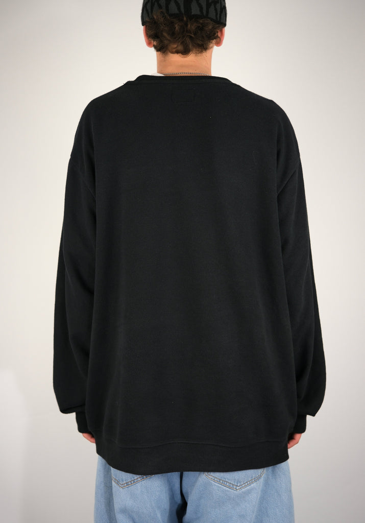 Black long-sleeved Dc Shoes terry cloth crew sweatshirt worn from behind