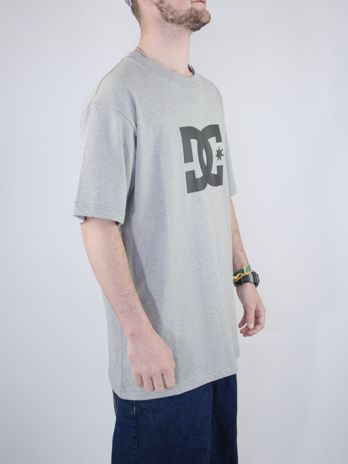 Grey DC logo t-shirt worn by someone.