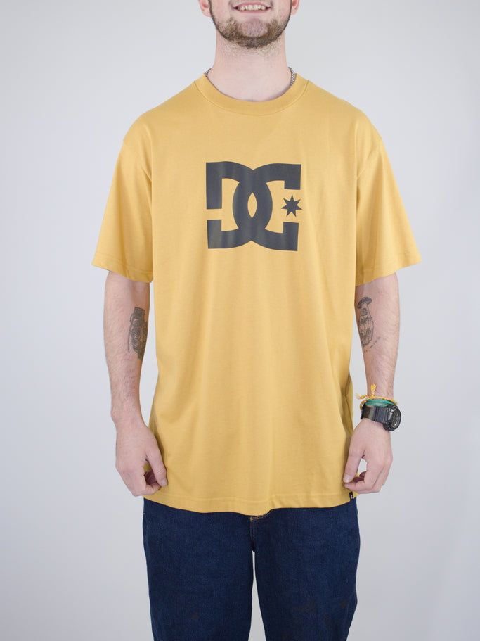 Yellow DC logo t-shirt with dark navy jeans.