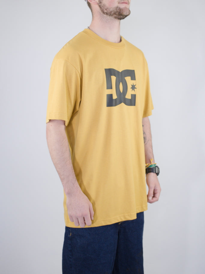 Yellow DC logo t-shirt with dark navy shorts.