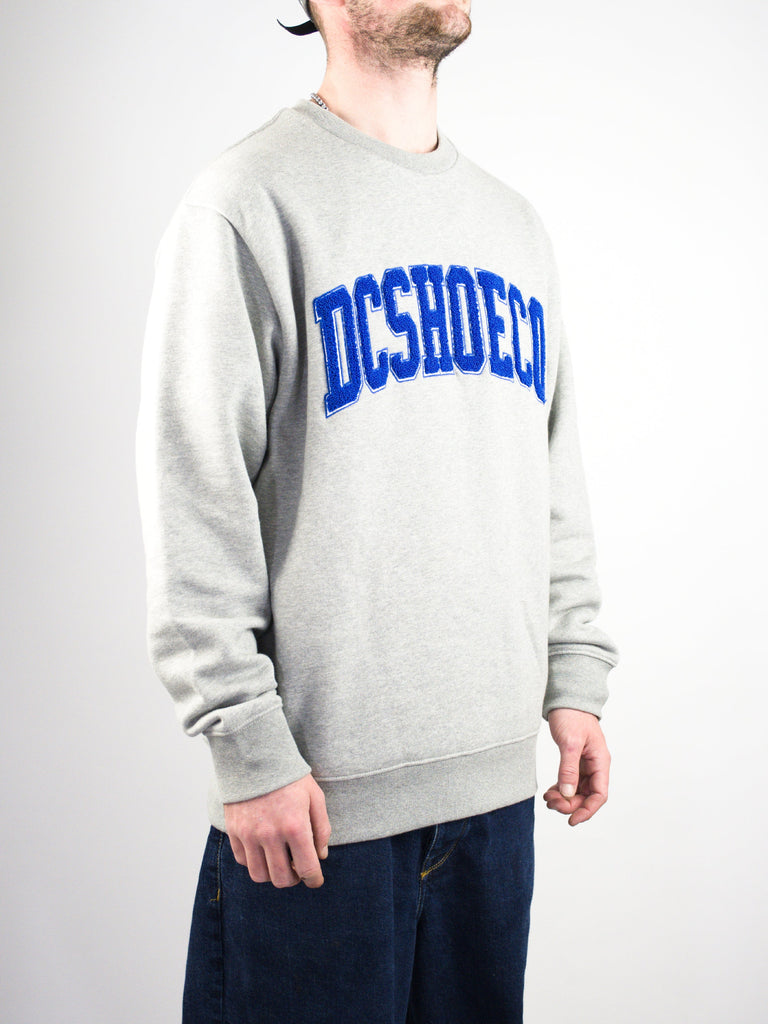 Grey sweatshirt with ’DC SHOES’ text in blue letters across the chest.