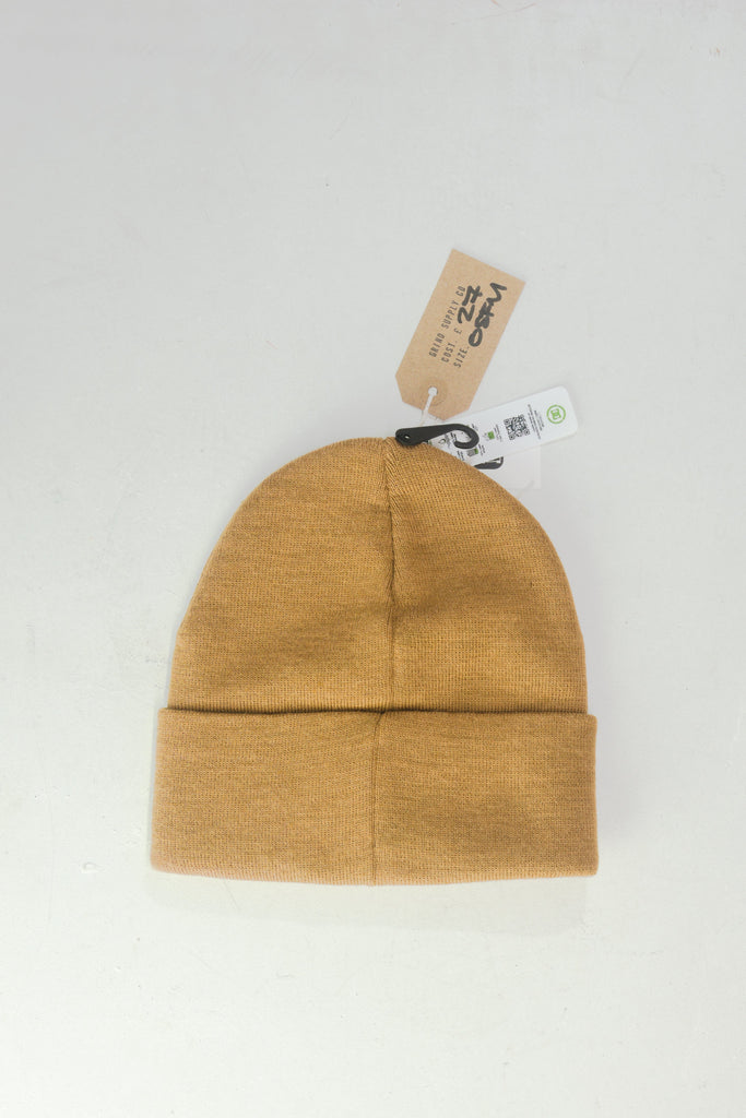 Mustard yellow knit beanie with a folded cuff and product tags attached.