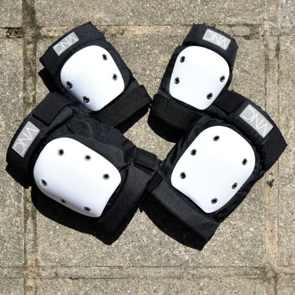 Set of black and white protective knee and elbow pads.