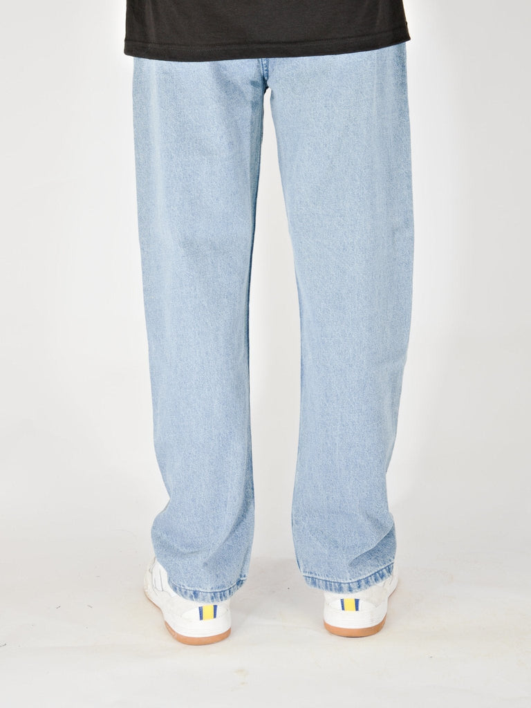 Light blue baggy fit denim jeans with white sneakers, by Grind Supply Co’s Acid Wash Blue