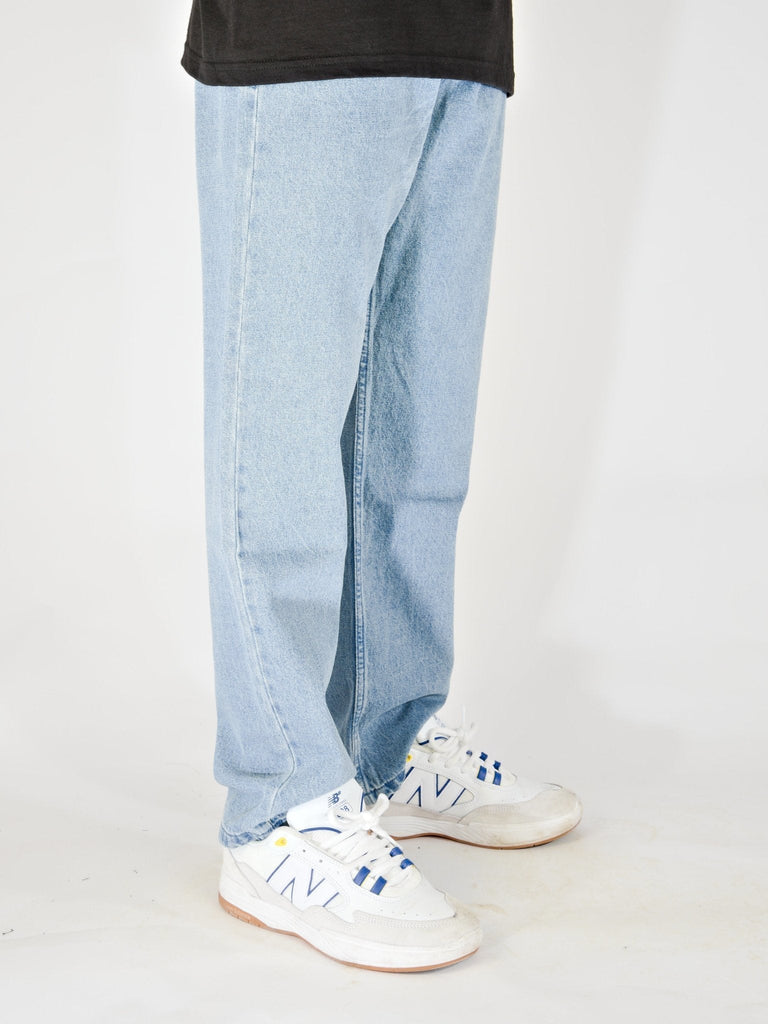 Light blue baggy fit denim jeans with white New Balance sneakers by Grind Supply Co’s