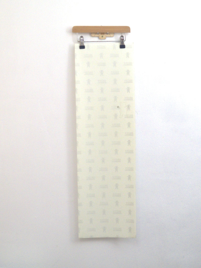 Long white panel on hanger showcasing Grizzly Clear Cut 10’’ Grip Tape Sheet