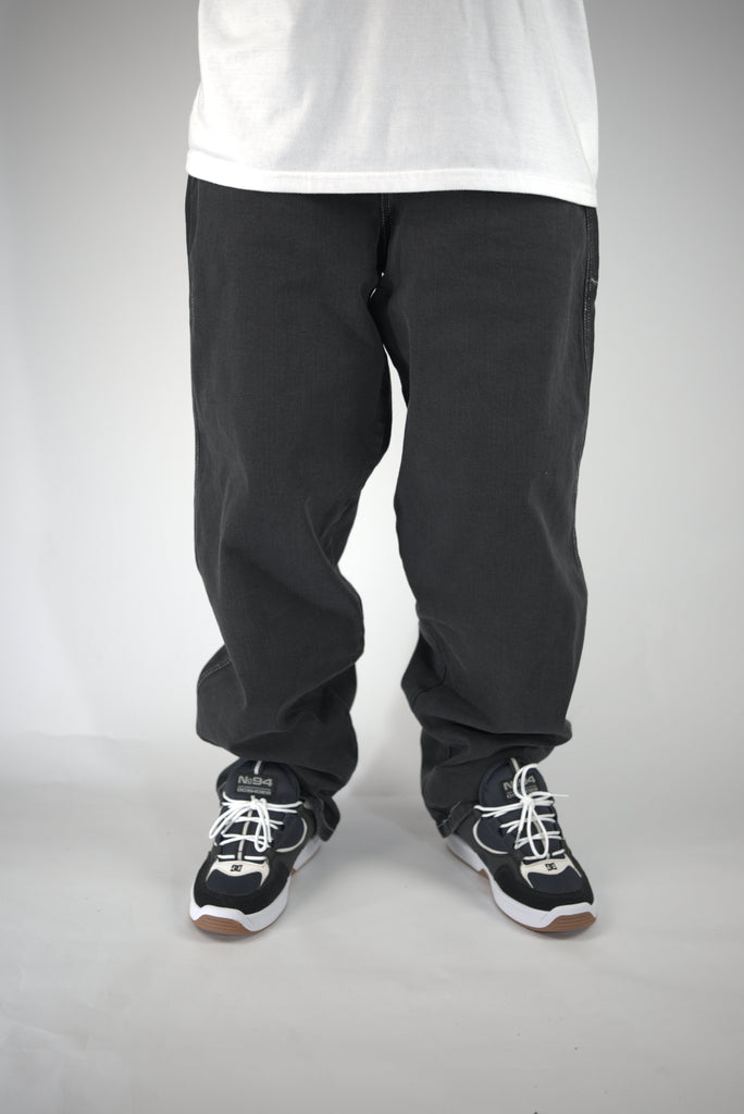 Pair of loose-fitting black pants with athletic shoes under Homeboy Xtra Monster Baggy Fit Denim