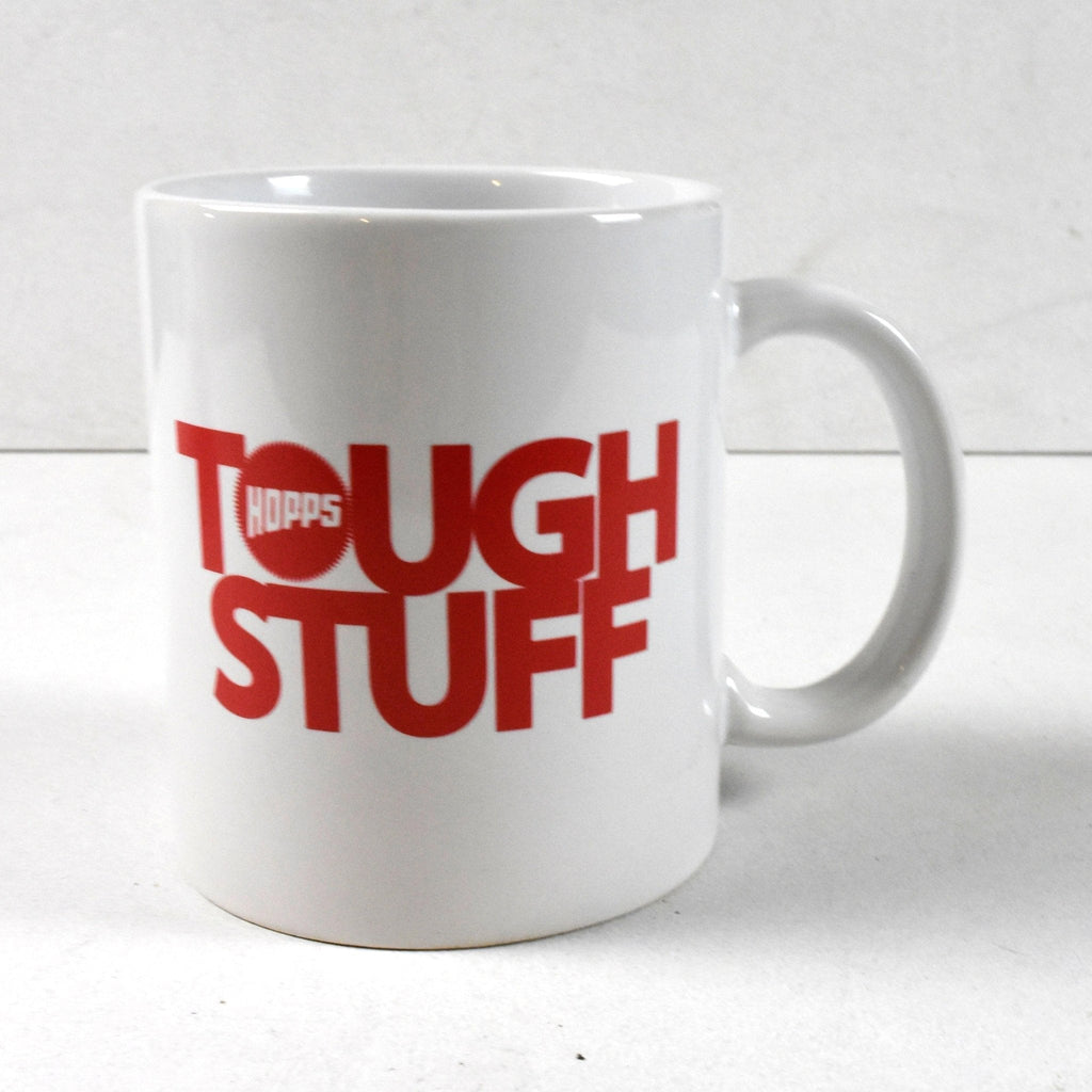 White ceramic Hopps Tough Stuff coffee mug featuring bold red lettering