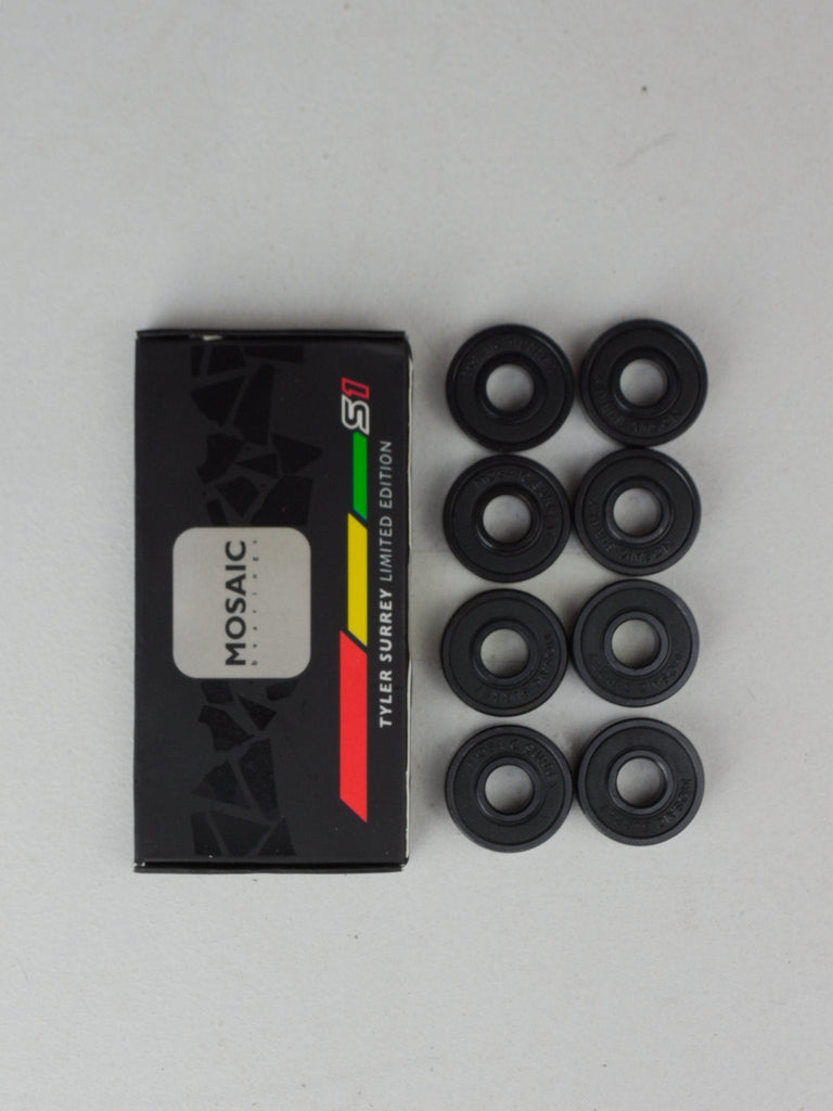 Box of Mosaic skateboard bearings with eight black bearing rings displayed next to it.