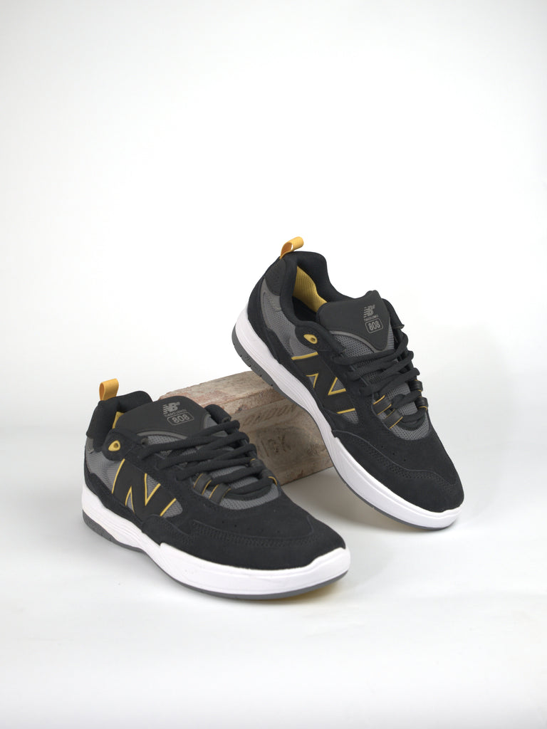 Black and gray athletic sneakers with yellow accents, Tiago Lemos’ pro skate shoe