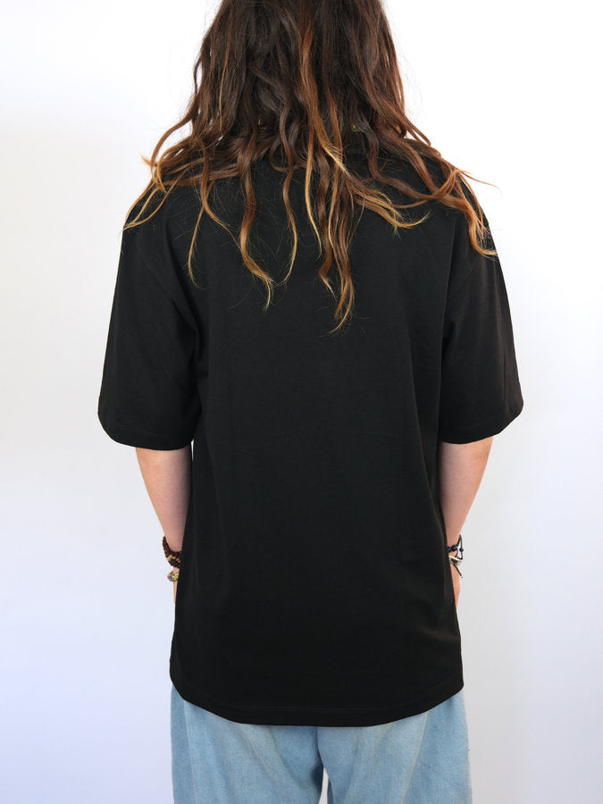 Black short-sleeved t-shirt with long brown hair cascading down the back.