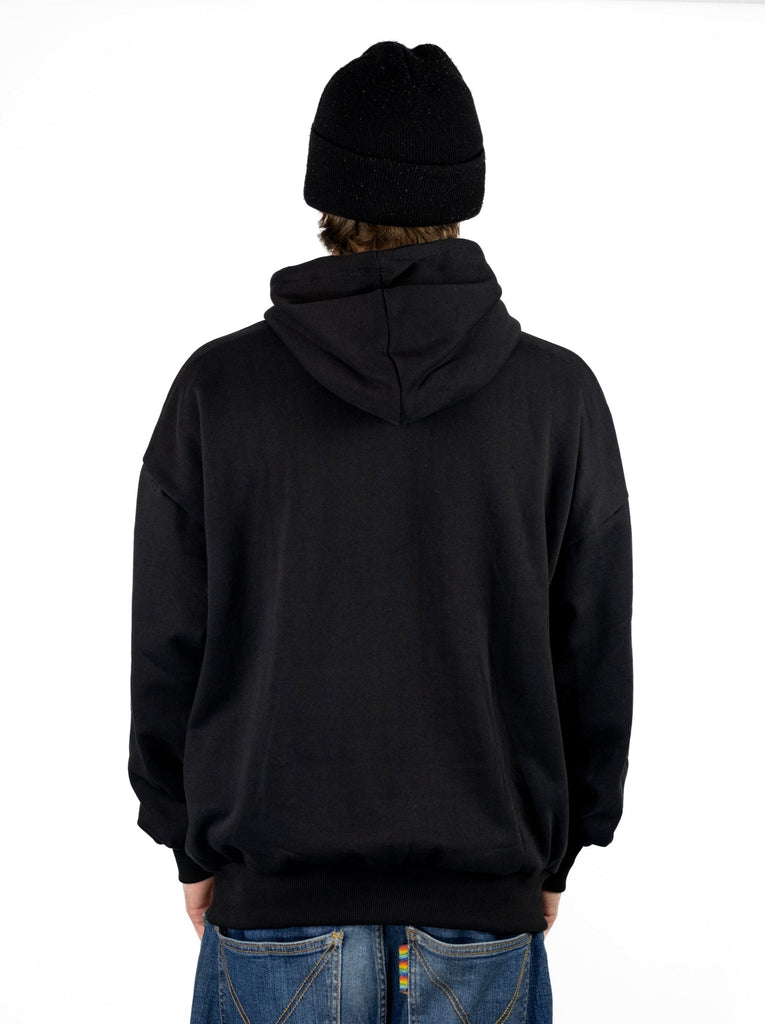 Black hooded sweatshirt worn by a person, showcasing Poetic Collective Ninja Hoodie in heavyweight organic cotton