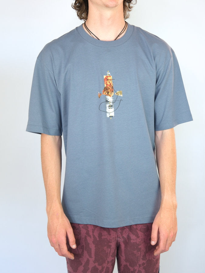 Blue t-shirt with a cartoon character embroidered on the front.