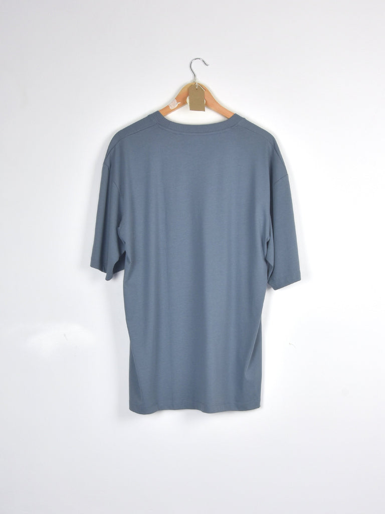Gray t-shirt hanging on a wooden hanger.