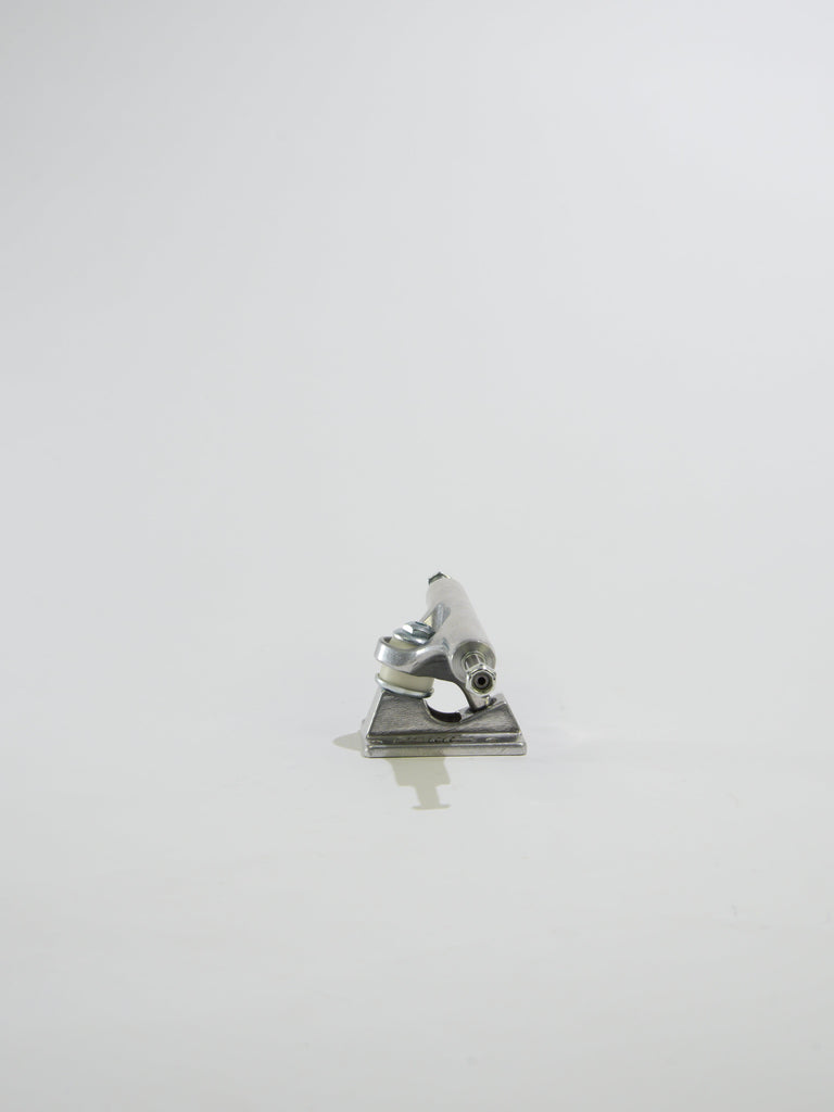 Metallic figurine of a person sitting at a desk or table.